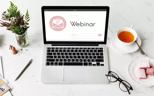 Na ekranie laptopa wyświetla się duży napis: Webinar