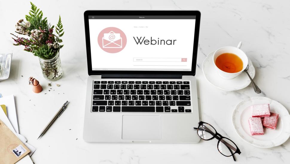 Na ekranie laptopa wyświetla się duży napis: Webinar