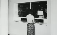 A woman outside the window of a former lending library.