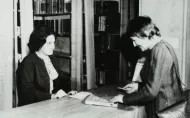 A student borrows a book in the former Library.