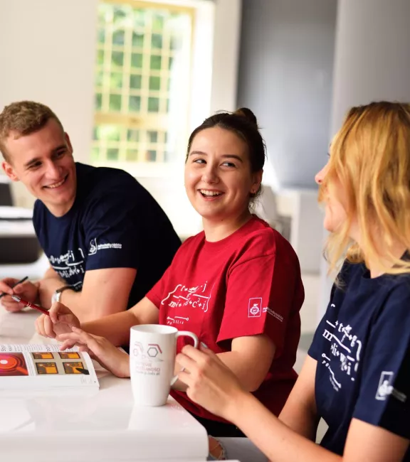 Studenci siedzący przy biurku.